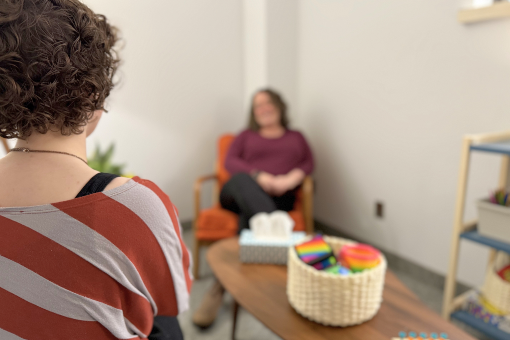 Teenager speaking to a therapist in a therapists office.